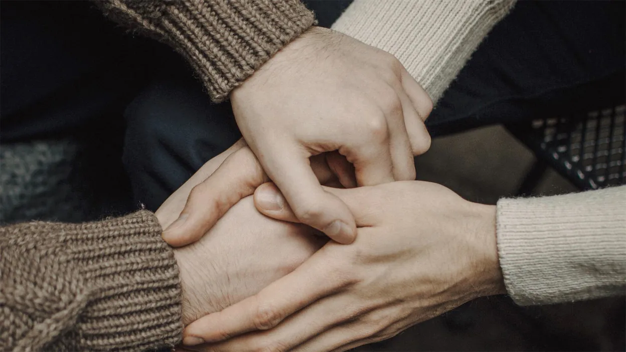 three people putting their hands together.